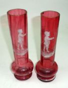 A pair of Cranberry Glass Spill Vases, each painted in the manner of Mary Gregory with motifs of