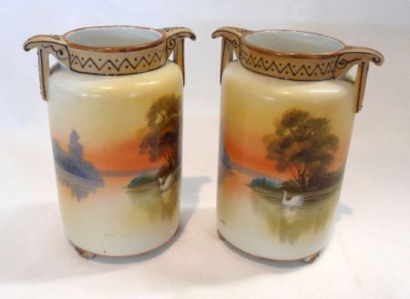 A pair of two-handled Noritake Cylinder Vases, decorated with pastoral sunset scenes with swans on a