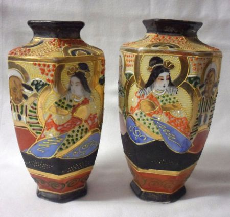 A pair of 20th Century Satsuma Vases of octagonal baluster form, decorated in heavy palette with