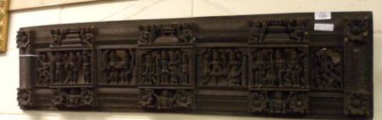 A Balinese type pierced and carved Ebonised Panel, decorated with mythological figures, musicians,