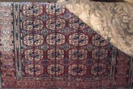 A 20th Century Bokhara style Wool Rug, with central panel of lozenges, mainly rust and puce field