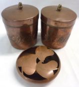 A pair of Copper Cylindrical Canisters, each with hinged covers and tinned liners, embossed with