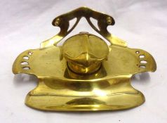 An early 20th Century Continental Brass Inkstand, the shaped and pierced base with integral pen