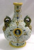 A European large Ewer, decorated in faience colours and the handles formed as coiled snakes with