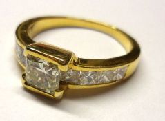 A modern high grade yellow metal Ring, featuring a centre shaped square cut Diamond of approximately