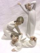 Three Lladro Models of a yawning child; young girl kneeling with a pair of shoes; and a young