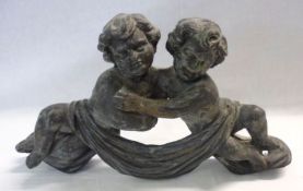 A Cast Metal Mount, modelled in the form of embracing putti with swag detail, width 14”