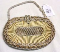 A Beaded Evening Purse of oval form with further beaded handle (A/F), width 5 ½”