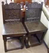 A pair of 18th Century and later Oak Hall Chairs, the backs carved with rosettes and scrolling