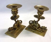 A pair of Cast Brass Candlesticks, each with spreading rectangular facetted bases and surmounted