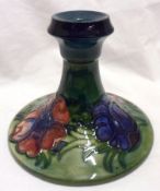 A Moorcroft Candlestick of spreading circular form, decorated with an anemone design on a washed