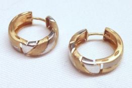 A pair of high grade precious metal two-tone hollow loop Earrings of modern design, stamped “750”,