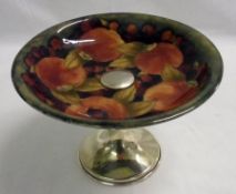 A Moorcroft Tazza with silver plated or chromium stand, decorated with pomegranate design, impressed