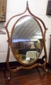 A 19th Century Mahogany Swing Mirror, the arched frame crested with an urn finial with a swept