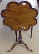 A 19th Century Mahogany Pedestal Table with a pie-crust top, raised on a fluted and foliate carved
