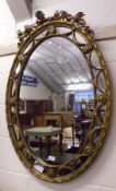 A 19th Century Gilt and Gesso large Oval Wall Mirror, crested with a ribbon and foliate mount and