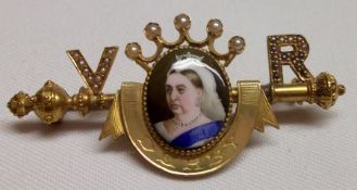 A Victorian unmarked yellow metal Bar Brooch, featuring to the centre an enamel portrait of Queen