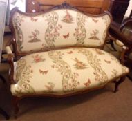 A Stained Beech Three-Seater Cottage Sofa, the curved back moulded with scrolls etc and with