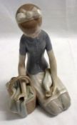 A Lladro Figure of kneeling girl with a dove and basket, decorated in the typical manner, 8” high