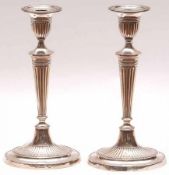 Two Edward VII Candlesticks in the Sheraton Revival manner, with oval urn shaped sconces with