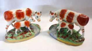 A pair of 19th Century Staffordshire Groups of cow and calf, standing on a sponged base decorated in