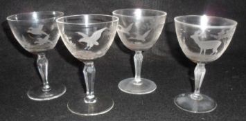 A set of four decorative Cocktail Glasses, each etched with deer in a landscape, bird of prey,