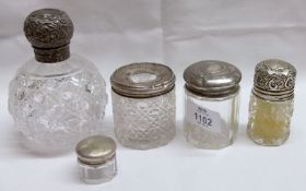 A Mixed Lot comprising: five various Silver Lidded and Clear Cut Glass Toiletry Bottles, including