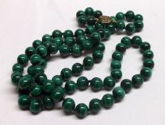 A long ungraduated Malachite Bead Necklace with gilt metal clasp