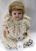 An early 20th Century British made Bisque Head Character Doll, features fixed blue glass eyes with