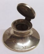 A George V Capstan Inkwell of typical polished form with hinged and domed cover, (lacking liner),