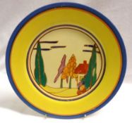 A Clarice Cliff Circular Plate, decorated with the “Trees and House” pattern, with a blue and yellow