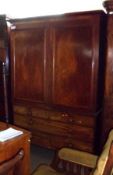 A Mahogany Linen Press, with moulded cornice over two panelled doors enclosing an altered interior