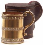 A Victorian parcel gilt Christening Mug of cylindrical form with applied rim and leaf-capped