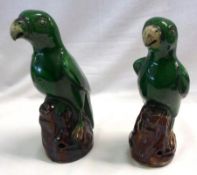 A pair of Majolica Models of perched parrots, each decorated in green on treacle bases, unmarked,