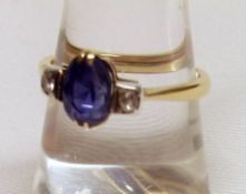 A high grade precious metal centre Ceylon Blue Oval Sapphire and two small Diamond Ring, stamped “