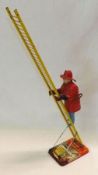 A Marx Tinplate Clockwork Climbing Fireman, on lithographed base with extending ladder, height