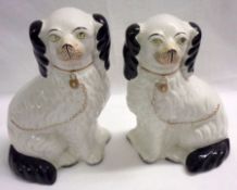 A pair of Staffordshire Model of seated dogs, faces with naturalistic detail, black body markings