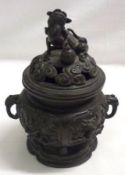 An Oriental Bronze Patinated Cast Metal Koro, the pierced cover with Kaolin finial, applied on