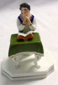 A 19th Century Staffordshire Model of a devout young man praying before an open bible on a table,