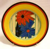 A Clarice Cliff Small Circular Tea Plate, decorated with the “Umbrellas” design in red and blue,