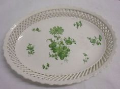 An oval Dish with pierced latticed border and the centre decorated in green with floral sprigs and