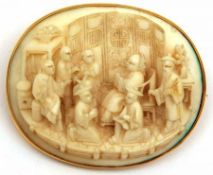 A good quality Chinese Gold Framed Ivory Brooch, relief carved with seven seated and standing