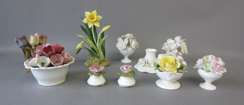 Collection of porcelain & bisque floral groups plus ceramic candle stick (10)