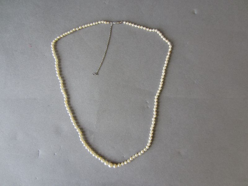 Single string of graduated natural pearls with safety chain (complete with FGA radiography report)