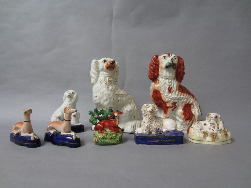 Group of Staffordshire figures to include two spaniels, two greyhound penholders & a bocage group of