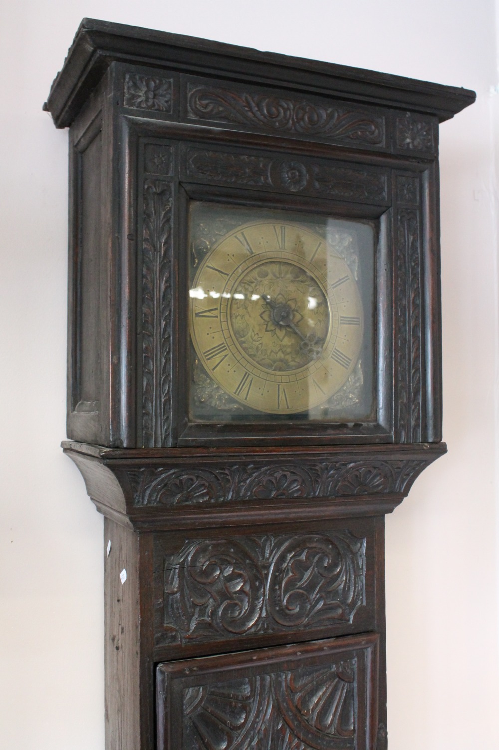 A provincial carved oak longcase 30-hour clock with brass dial engraved `John Warner Draycott`,