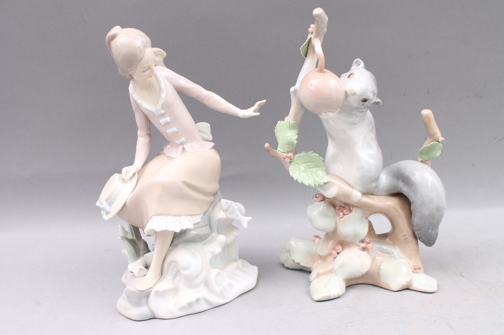 A Lladro figure of a squirrel on tree stump 23cm high, and another modelled with a seated lady on