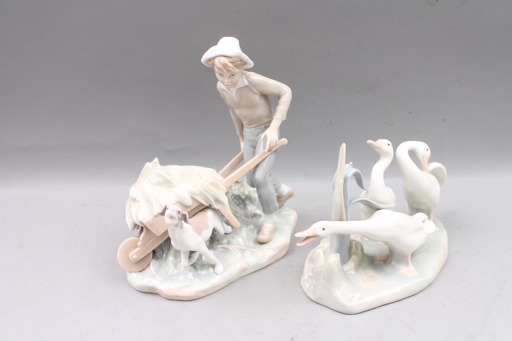 A Lladro figural group modelled with three geese, 24cm long, and another modelled with a boy with