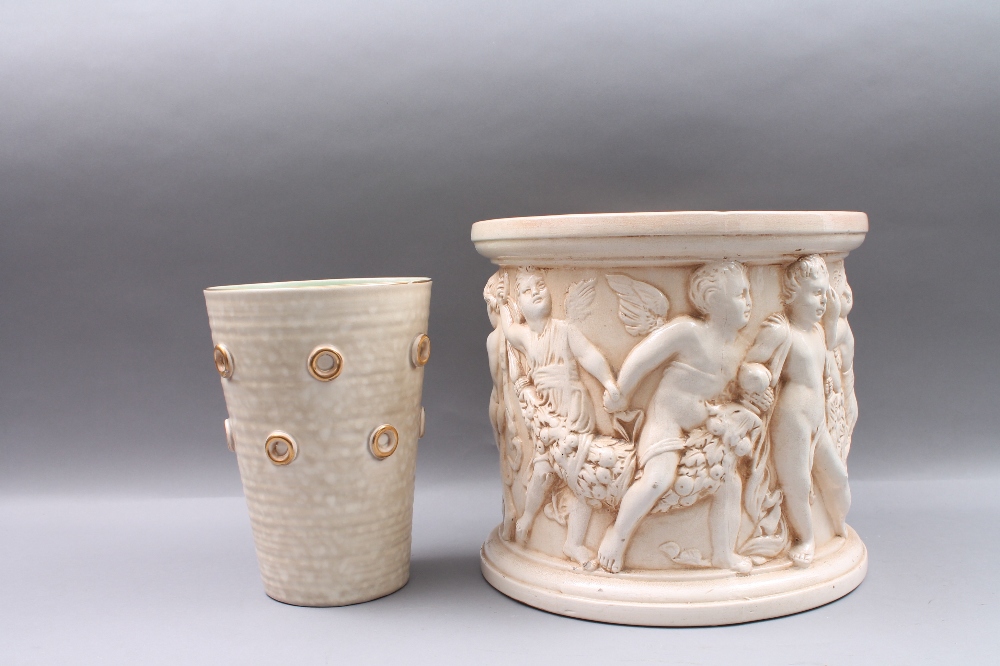 A Bretby jardiniere with relief moulded decoration of cherubs, 27.5cm high, impressed `Bretby