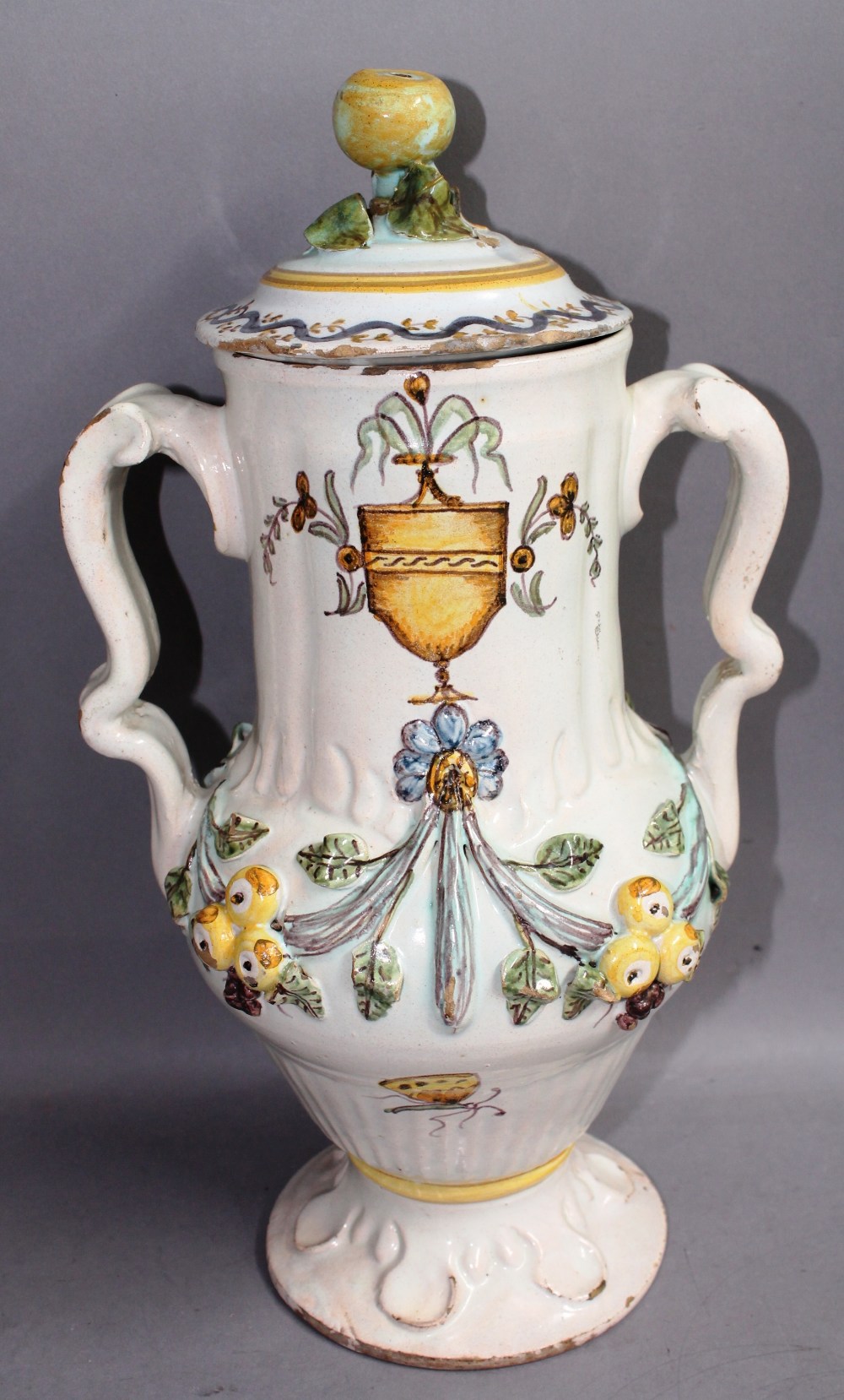 A large maiolica twin handled lidded vase, 37.5cm high, relief moulded decoration of fruit and